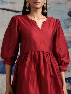 Cotton silk gathered kurta with U-hemline and contrast piping & facing, along with pleated pants Maroon