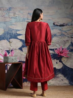 Cotton silk gathered kurta with U-hemline and contrast piping & facing, along with pleated pants Maroon