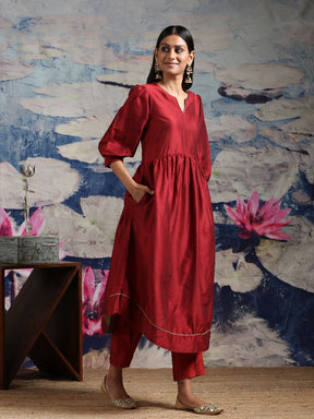 Cotton silk gathered kurta with U-hemline and contrast piping & facing, along with pleated pants Maroon